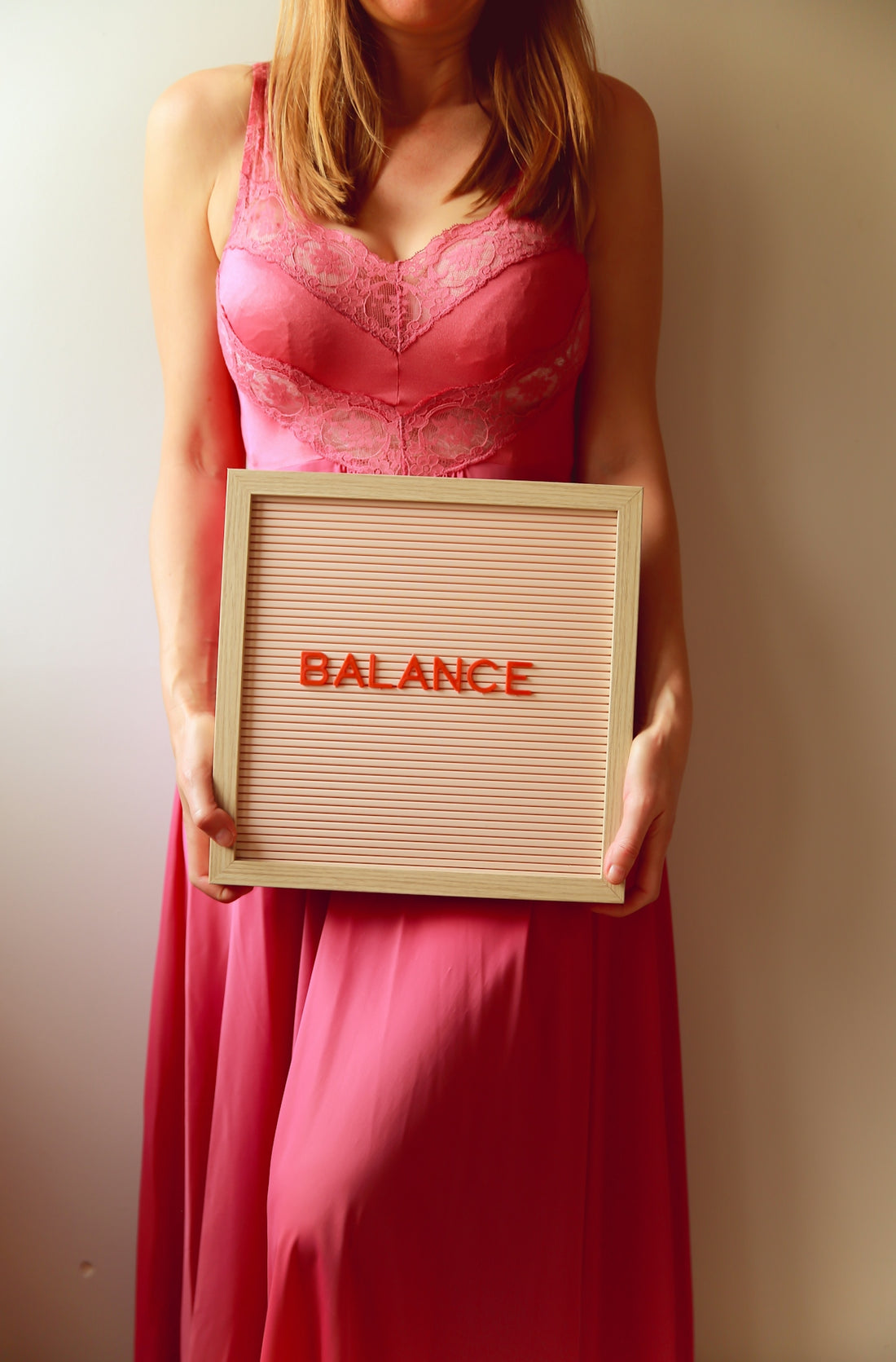 Woman holds a sign that says balance.