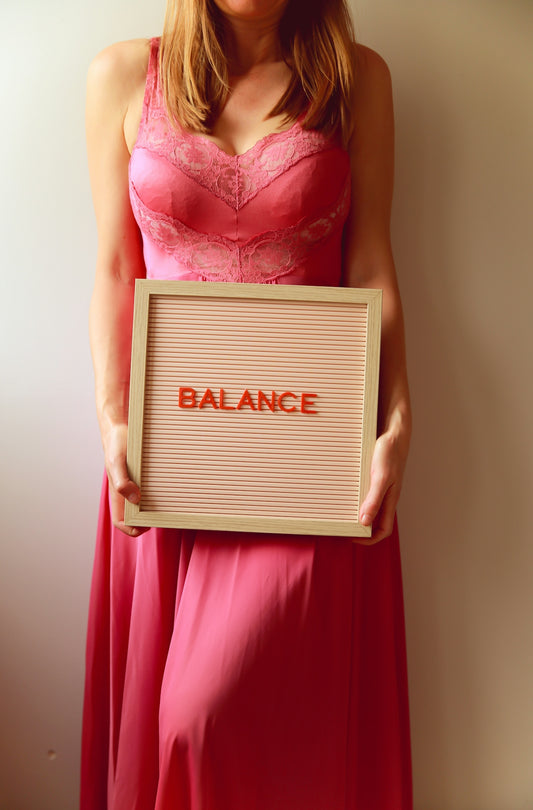 Woman holds a sign that says balance.