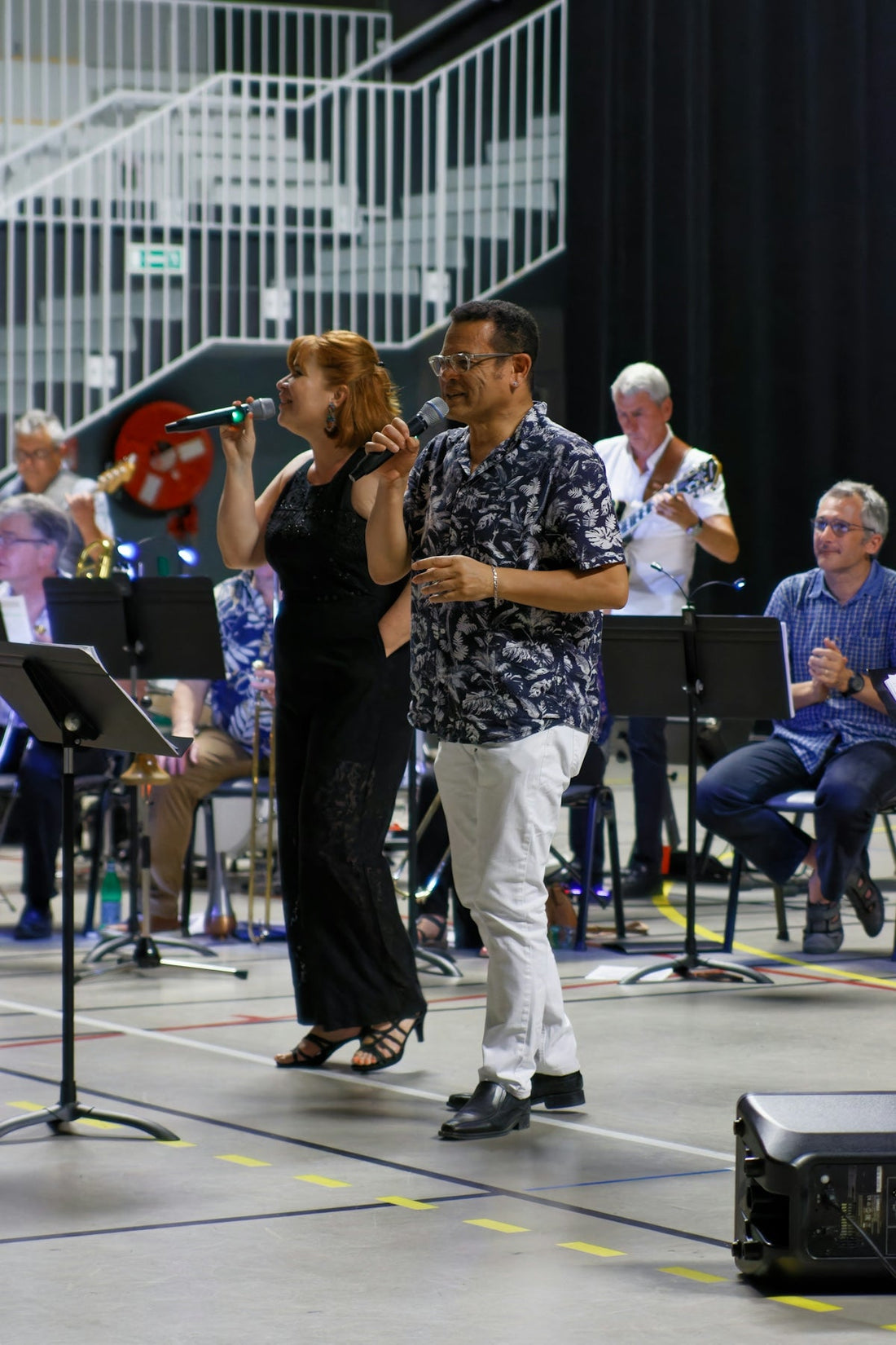 A male and female singer perform with a band.
